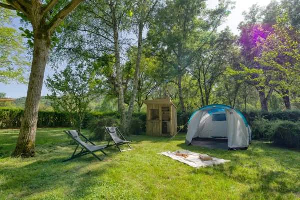 Emplacement avec une Slow Box (box avec sanitaires et cuisine privés) et une tente en pleine nature