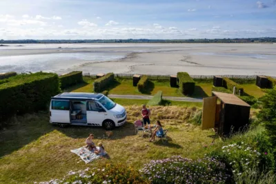 Emplacement avec un camping car et une Slow Box (box avec sanitaires et cuisine privés) devant la mer